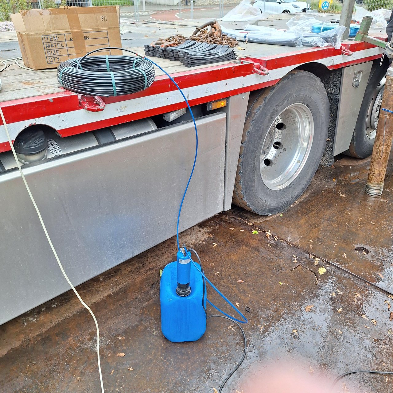 Kleine pomp in een jerrycan met blauwe leiding naast de vrachtwagen tijdens de werkzaamheden bij Mijnwater in Heerlen